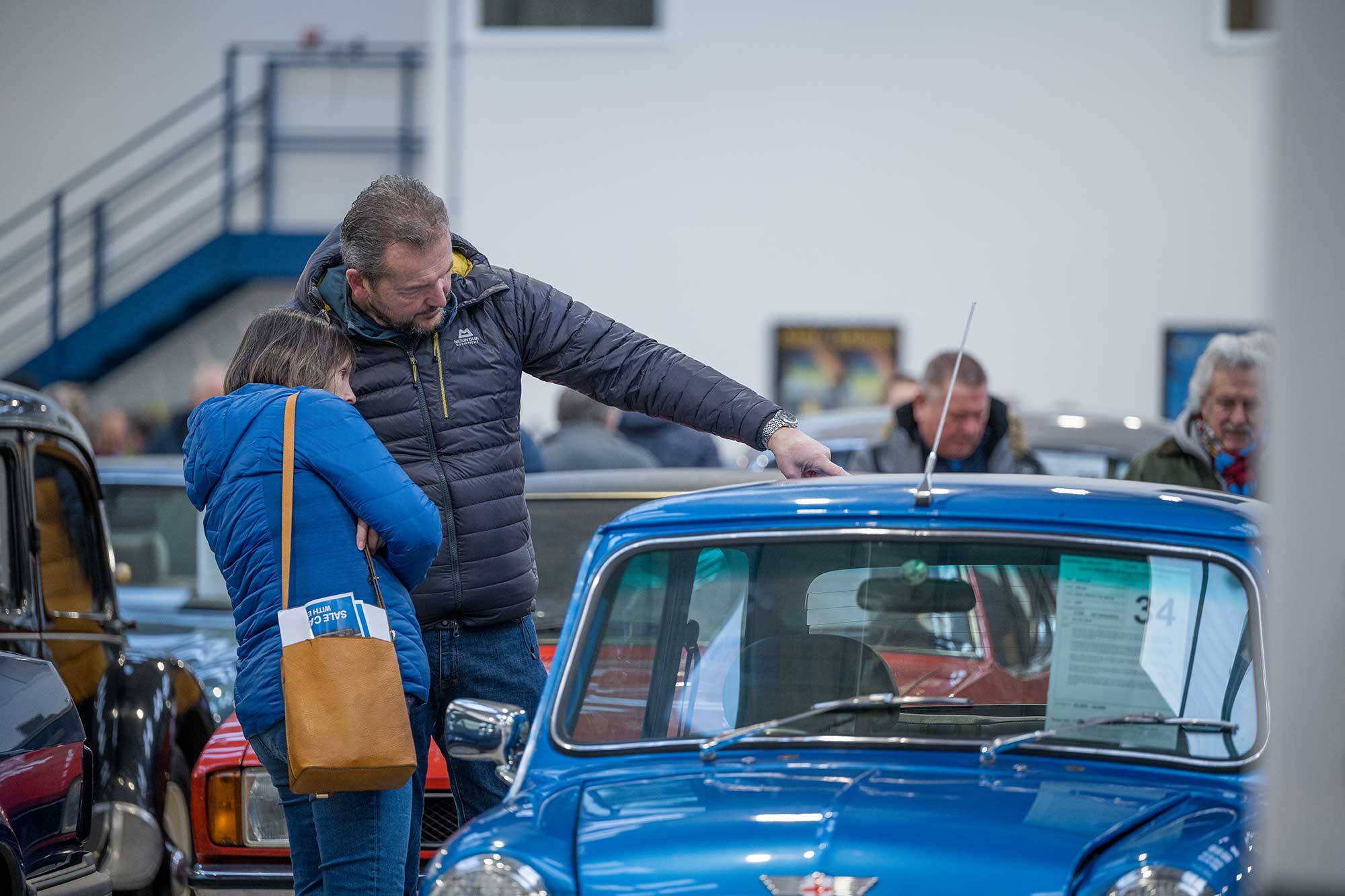 People inspecting classic car